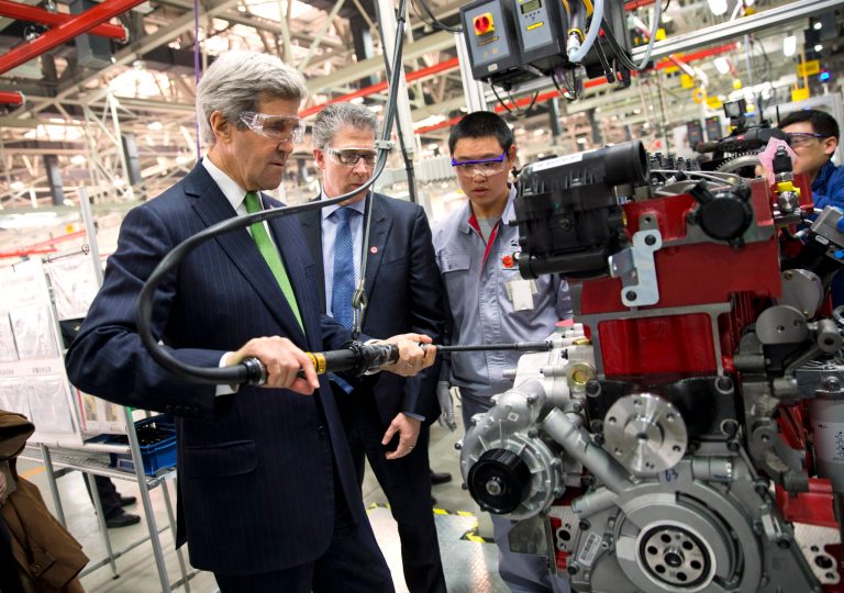U.S. Secretary of State John Kerry, left, torques an engine bolt during a tour of the Foton Cummins Engine plant in Beijing, China Saturday, Feb. 15, 2014. Kerry toured the plant and made remarks on climate change cooperation between the United States and China. (AP Photo/Evan Vucci, Pool)