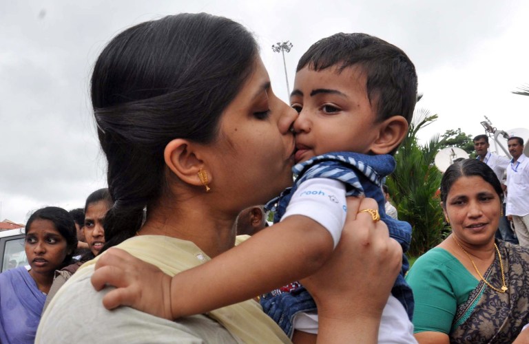 An Indian nurse, who was among 46 nurses stranded in territory held by Islamic extremists in Iraq, kisses her nephew upon arrival at the airport in Kochi, India, Saturday, July 5, 2014.  The nurses who had been holed up for more than a week in Tikrit, returned home to southern India on Saturday aboard a special flight, officials said. (AP Photo/Satheesh)