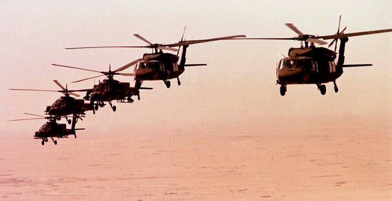 Three Apache helicopters from the North Carolina National Guard, left, escort two Black Hawk helicopters from the Alabama National Guard as they fly a mission over the Kuwait desert Oct. 12, 1998. (AP Photo/Bob Jordan)