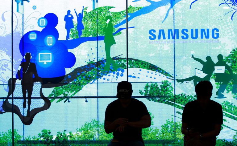 People stand in front of a Samsung Electronics Co's showroom in Seoul, South Korea, Thursday, July 31, 2014. Samsung Electronics Co. reported a bigger-than-expected fall in second quarter profit on Thursday and said it was uncertain if earnings from its handset business would improve in the current quarter.(AP Photo/Ahn Young-joon)