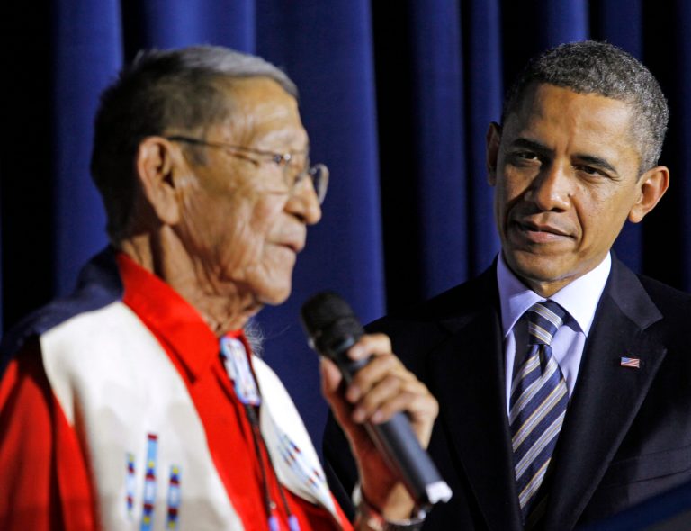   FILE - In this Friday, Dec. 2, 2011 file photo, President Barack Obama listens as Hartford âSonnyâ Black Eagle delivers remarks at the White House Tribal Nations Conference at the Interior Department in Washington. Native American tribal leaders are concerned that steady progress on their issues might be undermined if President Barack Obama and Congress make deep spending cuts in order to avoid the âfiscal cliff.â More than 500 tribal leaders were taking those concerns to the fourth White House Tribal Nations summit, which convenes Wednesday, Dec. 5, 2012. Obama is scheduled to address the group in the afternoon. (AP Photo/Haraz N. Ghanbari, File)  