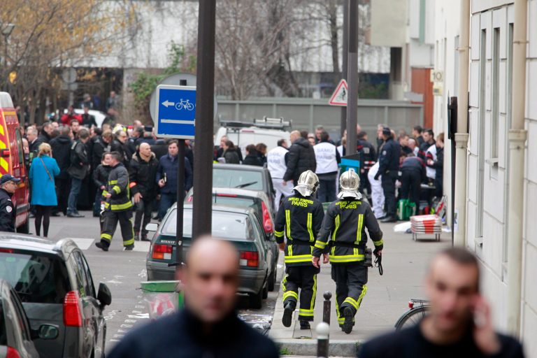 Police officers and rescue workers gather at the scene after gunmen stormed a French newspaper, killing at least 12 people, in Paris, France, Wednesday, Jan. 7, 2015. (AP Photo/Remy de la Mauviniere)