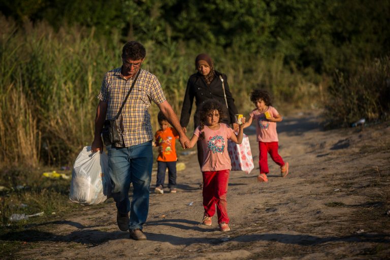 Syrian refugees cross the border from Macedonia to Serbia next to the train station of Tavanovce, on Friday Aug. 28, 2015. (AP Photo/Santi Palacios)
