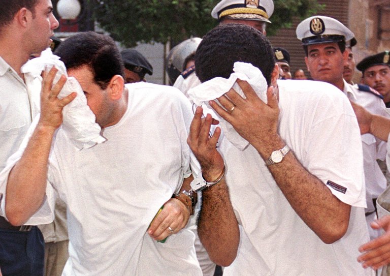 FILE - In this Wednesday, July 18, 2001 file photo, two of 52 men accused of breaking laws covering obscenity and public morality cover their faces as they enter a state security court for their trial, in Cairo, Egypt. On Saturday, Sept. 6, 2014, Egypt's top prosecutor has ordered seven men detained and physically examined over accusations of 