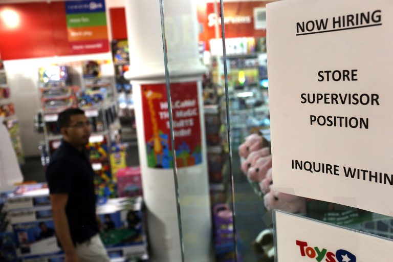 A 'now hiring' sign is viewed in the window of a toy store on August 7, 2012 in New York City. (Photo by Spencer Platt/Getty images)