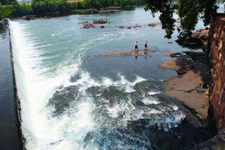 In a June 11, 2011 photo, men walk on the rocks in the Chattahoochee River below the City Mills dam near Columbus, Ga. Leaders of a national land trust say a river that runs through metro Atlanta holds the key to realizing a grand vision for outdoor enthusiasts. They aim to create an extension of the Appalachian Trail that would allow hikers to traverse the mountains from Maine to north Georgia, then continue on in a canoe or kayak to the Gulf of Mexico. Leaders of the National Trust for Public Land say the effort is years away, but they believe it can be accomplished within 10 years. They're already working to make large sections of the Chattahoochee River easy to navigate, including one stretch from West Point, Ga. to Columbus. (AP Photo/The Ledger-Enquirer, Robin Trimarch)