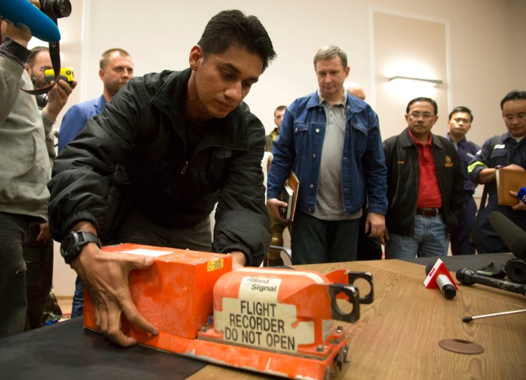 A Malaysian investigator takes a black box from Malaysia Airlines Flight 17 as it is handed over from Donetsk People's Republic officials to Malaysian representatives in the city of Donetsk, eastern Ukraine Tuesday, July 22, 2014. Bowing to international pressure Monday, pro-Moscow separatists released a train packed with bodies and handed over the black boxes from the downed Malaysia Airlines plane, four days after it plunged into rebel-held eastern Ukraine. (AP Photo/Dmitry Lovetsky)