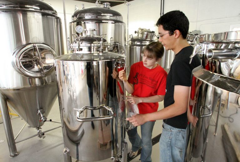 In this photo taken July 14, 2014, Dayna and Mike Tran begin the setup of brewery equipment at Eternity Brewing Co. in Genoa Twp., Mich. The Colorado-based Brewers Association ranked Michigan 14th last year in number of breweries at about 150 last year. (AP Photo/Livingston County Daily Press & Argus, Alan Ward) NO SALES