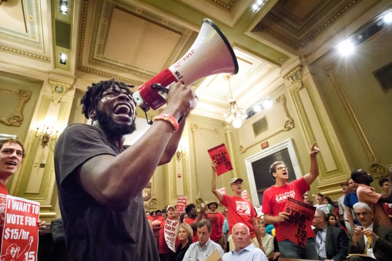 Organizers of march for $15 wage link up with Black Lives Matter, liken opponents to backers of slavery. (Glen Stubbe/Star Tribune via AP)