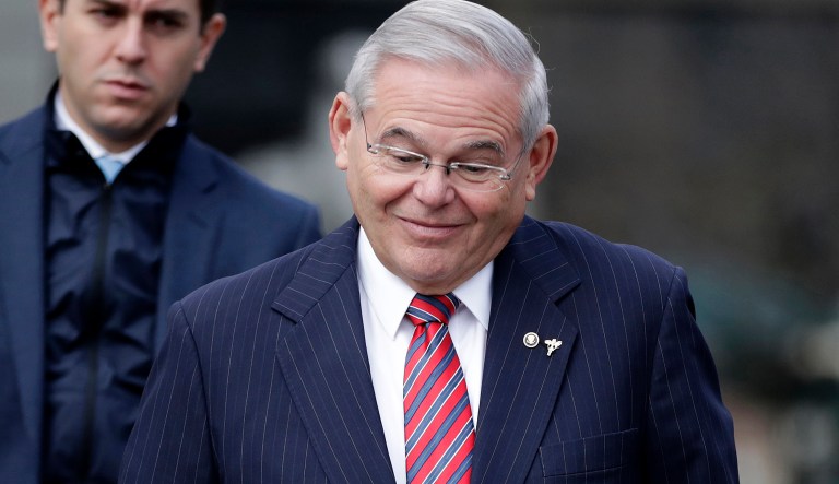 U.S. Sen. Bob Menendez shrugs as reporters ask him questions while leaving Martin Luther King Jr. Federal Courthouse after stopping by for his federal corruption trial, Thursday, Nov. 16, 2017, in Newark, N.J. (AP Photo/Julio Cortez)