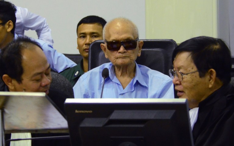 In this photo released by the Extraordinary Chambers in the Courts of Cambodia, Nuon Chea, center, who was the Khmer Rouge's chief ideologist and No. 2 leader, sits in the court room during a hearing at the U.N.-backed war crimes tribunal, in Phnom Penh, Cambodia, Friday, Oct. 17, 2014. A U.N.-backed Cambodian tribunal has begun hearing the first genocide case against the country's brutal 1970s Khmer Rouge regime.  (AP Photo/Extraordinary Chambers in the Courts of Cambodia, Nhet Sok Heng)
