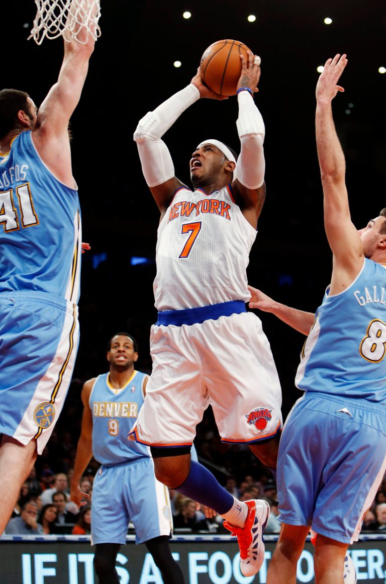   New York Knicks' Carmelo Anthony (7) shoots against Denver Nuggets' Kosta Koufus (41) and Danilo Gallinari (8) during the first half of an NBA basketball game, Sunday, Dec. 9, 2012, in New York. (AP Photo/Jason DeCrow)  