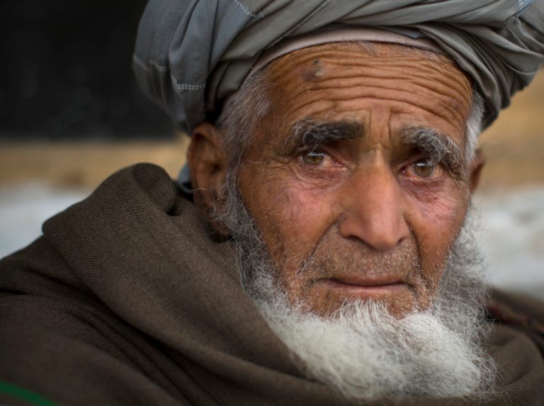 In this Wednesday, March 20, 2013 photo, Afghan villager Ghulam Rasool sits in the yard of his house where he and his family found refuge in the village of Khalis Family Village, Nangarhar province, Afghanistan. Rasool padlocked his front door, handed over the keys and his three cows to a neighbor and in the middle of the night left his mountain home to escape relentless air strikes. (AP Photo/Anja Niedringhaus)