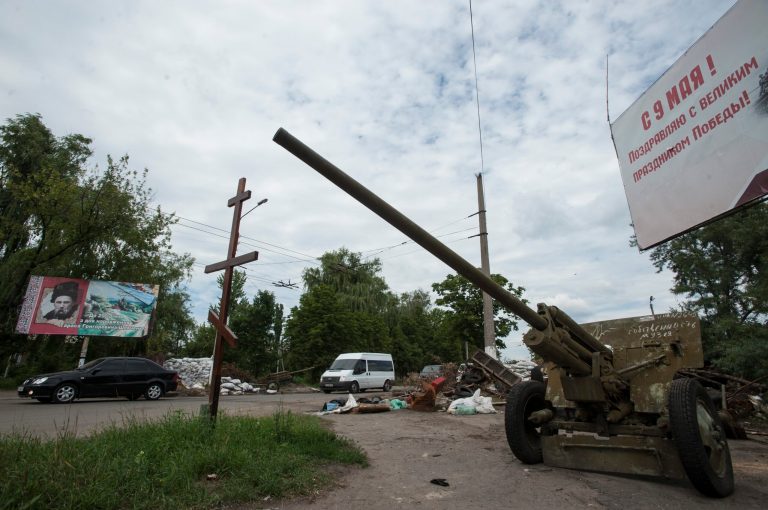 Cars pass an empty pro-Russian checkpoint after heavy fighting between pro-Russian fighters and Ukrainian government troops outside Slovyansk, eastern Ukraine, Wednesday, July 9, 2014. The rebels fled Slovyansk, a city of 100,000 that had been their stronghold, over the weekend as Ukrainian troops mounted an offensive. They left behind a city heavily damaged by fighting and riven by vehemently differing views. (AP Photo/Evgeniy Maloletka)