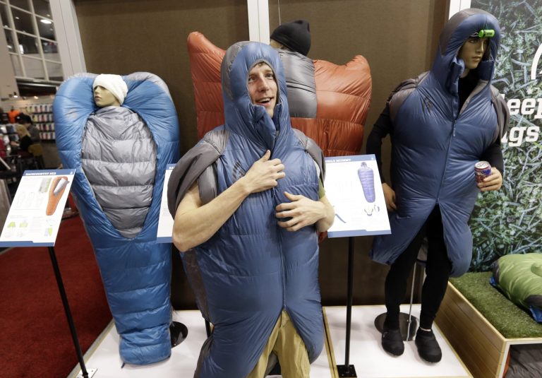 Mike Newlands wears the Backcountry Bed in the Sierra Designs booth at the Outdoor Retailer Winter Market show Wednesday, Jan. 22, 2014, in Salt Lake City. One trend at the world's largest outdoor-gear trade show in Salt Lake City is equipment that makes outdoor living fashionable, easy or comfortable. The Outdoor Retailer Winter Market show that runs through Saturday is a merchandise bazaar for a lifestyle of outdoor adventure. Bringing together 1,000 of the world's manufacturers and distributors, it is a showcase for the latest gear and fashions. (AP Photo/Rick Bowmer)