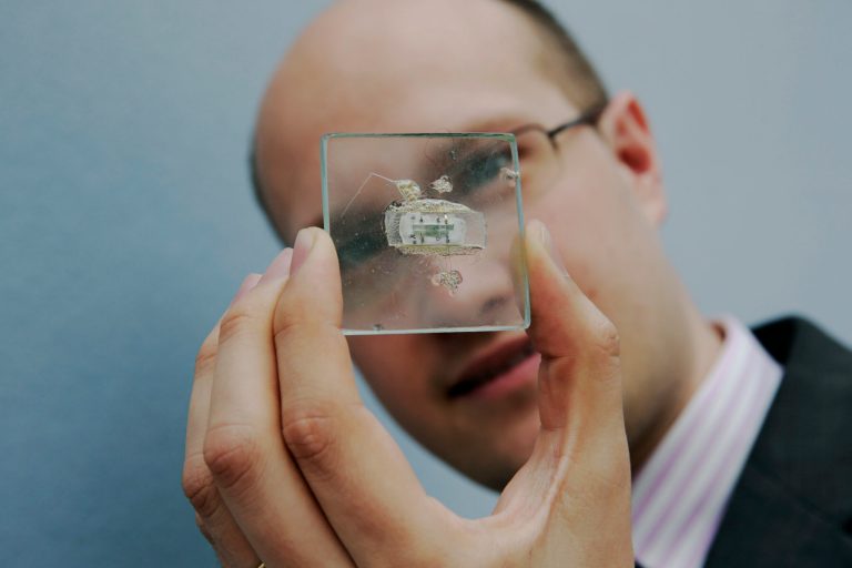 FILE - In this May 23, 2014 file photo, Christie's Head of Travel, Science and Natural History Sale James Hyslop poses for photographs with a 1958 prototype integrated circuit mounted on glass designed by Nobel Prize Physics winner Jack Kilby at Texas Instruments, at premises of the auction house in London, Friday, May 23, 2014.  The prototype microchip, a historical contribution to the modern computing era, is estimated to fetch between $1,000,000 and $2,000,0000 at a June 19 sale in New York.  (AP Photo/Matt Dunham, File)