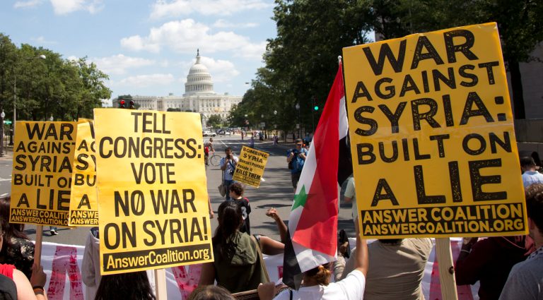 Protesters against U.S. military action in Syria march to Capitol Hill from the White House in Washington Saturday. (AP Photo/Carolyn Kaster)