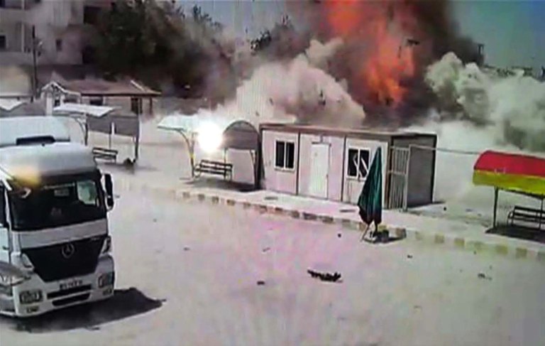 In this still image taken from video captured on a CCTV camera, made available Thursday, June 25, 2015, an explosion is captured by a camera on the Turkish side of the border, moments after a car bomb detonates in the town of Kobani, Syria. Islamic State militants staged a new attack on the Kurdish town of Kobani, which famously resisted a months-long assault by the Islamic militants. The attack involved a suicide car bombing that wounded scores. (AP Photo)