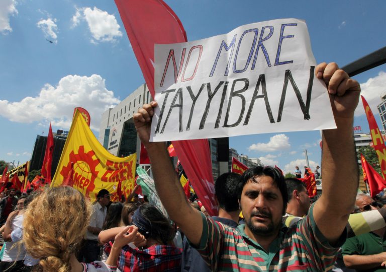 A Turkish protester holds a banner as thousands of trade union members who are on a two-day strike march to Kizilay Square, in Ankara, Turkey, Wednesday, June 5, 2013. A group of activists have met with Turkey's deputy prime minister to present demands that could end days of anti-government demonstrations if met. The group urged the government to end plans to develop a park in Istanbul, stop tear gassing protesters, and lift restrictions on freedom of expression and assembly. (AP Photo/Burhan Ozbilici)