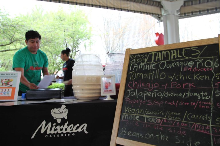 HOLD FOR MOVEMENT THURSDAY MAY 1  - In this photo Tuesday, April 15, 2014 photo, Gaudencio Felipe Asuncion prepares a traditional Oaxacan dish of tamales with mole sauce at the Lloyd Farmers Market in Portland, Oregon. The young man's mother, Paula Asuncion, started the food catering service after being part of a Portland micro-business development program for Spanish speakers run by Hacienda CDC. (AP Photo/Gosia Wozniacka)