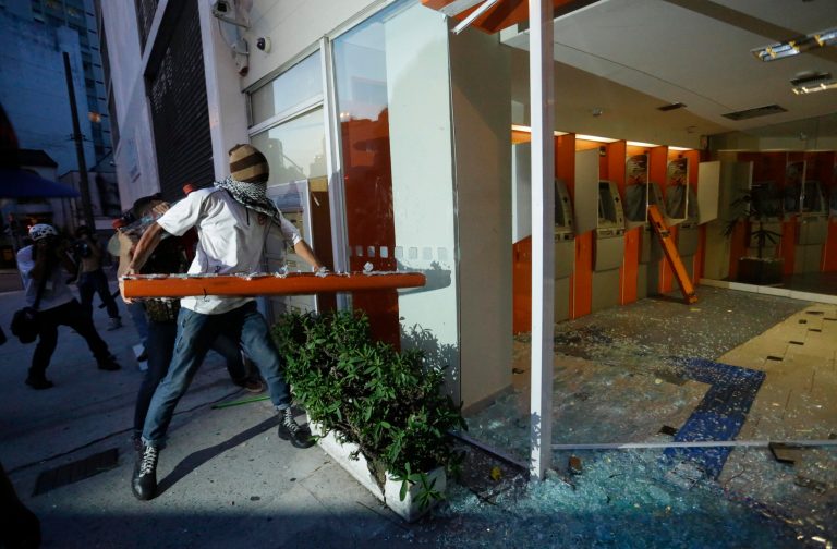 Demonstrators destroy a bank to protest the upcoming World Cup soccer tournament and demand better public services in Sao Paulo, Brazil, Saturday, Jan. 25, 2014. Last year, millions of people took to the streets across Brazil complaining of higher bus fares, poor public services and corruption while the country spends billions on the World Cup, which is scheduled to start in June. (AP Photo/Nelson Antoine)