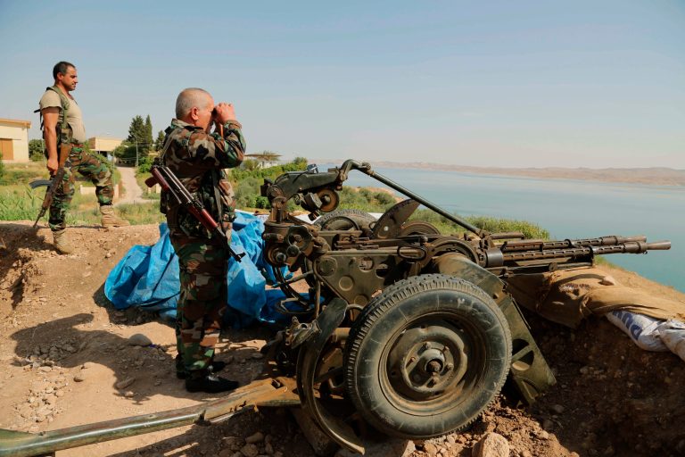 Kurdish forces, known as peshmerga, stand guard near Mosul Dam at the town of Chamibarakat outside Mosul, Iraq, on Sunday. (AP/Khalid Mohammed)