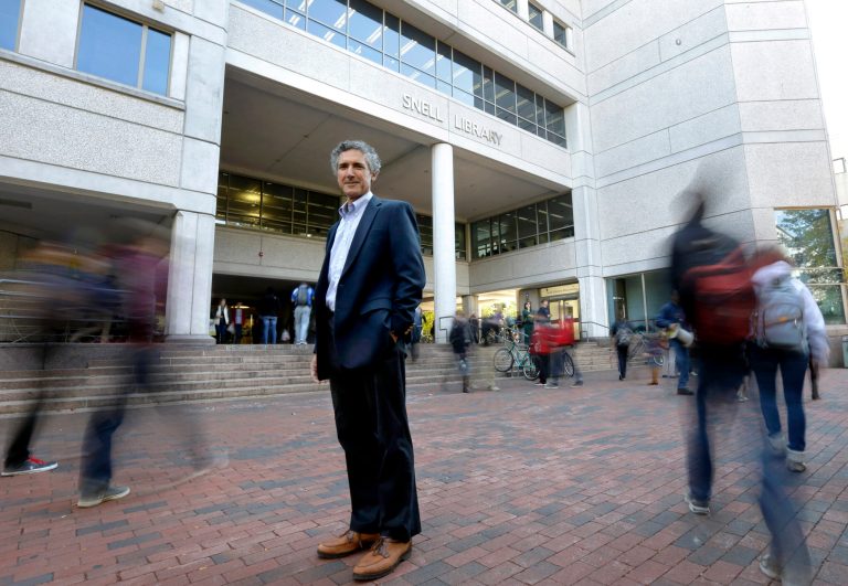 This photo taken Monday, Oct. 28, 2013, shows William Shimer, part-time lecturer in management and organizational development at Northeastern University, standing for a portrait on the school's campus, in Boston. Thousands of part-time college professors are joining labor unions, a growing trend in higher education that's boosting the ranks of organized labor and giving a voice to teachers who complain about low pay and a lack of job security at some of the nation's top universities. Shimer said he never imagined being part of the union movement. But he has been rallying his colleagues to support an upcoming vote on whether to form a union. Passers-by are blurred due to a low camera shutter speed. (AP Photo/Steven Senne)