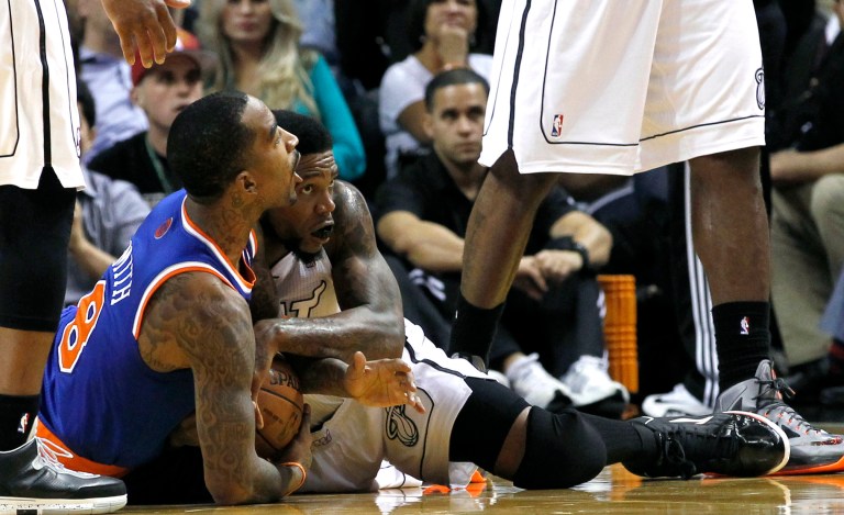   New York Knicks' J.R. Smith (8) battles Miami Heat's Udonis Haslem (40) for control of the loose ball during the first half of an NBA basketball game, Thursday, Dec, 6, 2012, in Miami. ( AP Photo/Alan Diaz)  