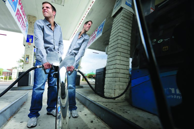 Ryan Goodman fills up his car at a gas station Friday, Oct. 5, 2012, in San Diego.