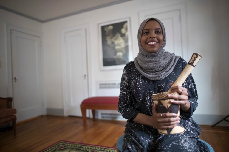 In this Saturday, Sept. 16, 2017 photo, Eiman Ali, of Somalia and born in Yemen, poses for a portrait during an interview in one of the bedrooms of President Donald Trump's boyhood home in the Jamaica Estates neighborhood of the Queens borough of New York. The house that Trump's father built is now a rental available on Airbnb. The international anti-poverty organization Oxfam rented it Saturday and invited refugees to share their stories with journalists. (AP Photo/Mary Altaffer)
