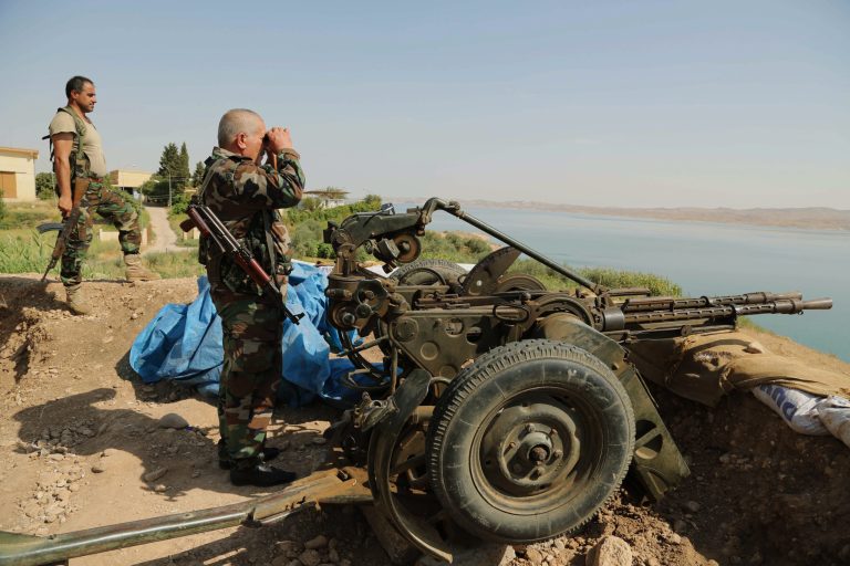 Kurdish forces, known as peshmerga, stand guard near Mosul Dam at the town of Chamibarakat outside Mosul, Iraq, Sunday, Aug. 17, 2014. Kurdish forces took over parts of the largest dam in Iraq on Sunday less than two weeks after it was captured by the Islamic State extremist group, Kurdish security officials said, as U.S. and Iraqi planes aided their advance by bombing militant targets near the facility. (AP Photo/Khalid Mohammed)
