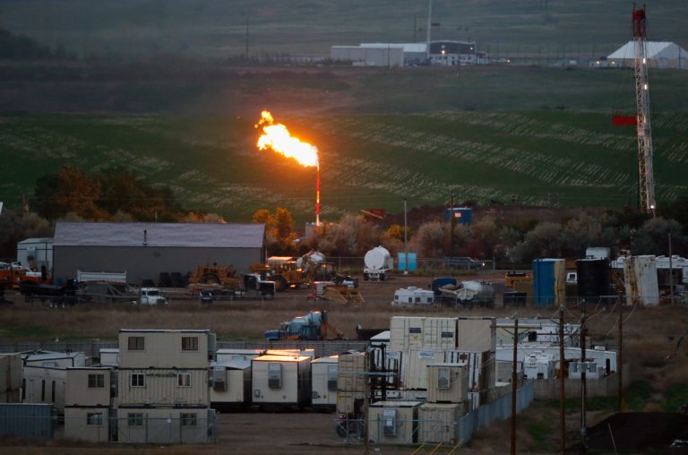 In this Monday, June 9, 2014, natural gas is flared at an oil production facility in Williston, N.D. On Tuesday, July 1, 2014, North Dakota regulators adopted the most stringent rules to date aimed at reducing the amount of natural gas that is burned off and wasted as a byproduct of the state's soaring oil production. The state Industrial Commission unanimously endorsed a policy that sets goals to reduce flaring in incremental steps through 2020. (AP Photo/Charles Rex Arbogast)