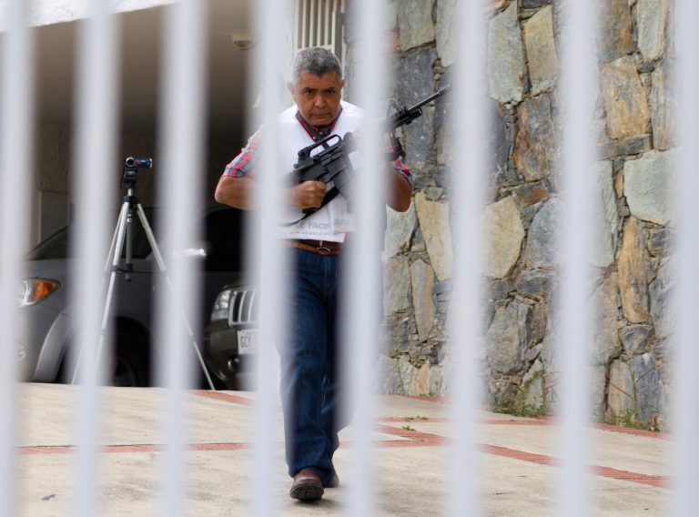 Retired Venezuelan Army Gen. Angel Vivas, armed and wearing a flak jacket, walks on his property in Caracas, Venezuela, Sunday, Feb. 23, 2014. President Nicolas Maduro ordered on Saturday the arrest and investigation of the retired general for his statements on YouTube and Twitter. Maduro said Vivas is instigating violence at a time when two weeks of anti-government protests have left 10 dead and over 100 wounded. Vivas has been an opponent of the Venezuelan government since his 2007 resignation as director of the Ministry of Defense Engineering, due to the military's adoption of the slogan 