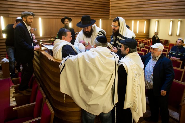   FILE - In this Oct. 29, 2012 file picture mohel doctor Yacov Gassinovitch, center, is surround by other Rabbis and relatives as he holds eight days old Jonathan during the boy's circumcision at synagogue in Berlin. German Parliament is expected to vote on legislation clarifying the legality of infant male circumcision for religious reasons. The government drew up the legislation after a court in June ruled the practice could amount to criminal bodily harm â prompting outrage in Germany's Jewish and Muslim communities. (AP Photo/Markus Schreiber)  