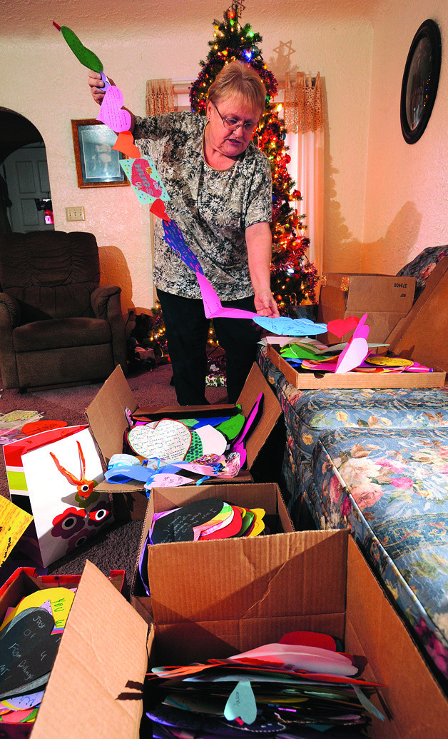 In this Monday, Dec. 24, 2012 photo, Joy Manning, neighbor of program coordinator Gala Thompson, sorts some of the hundreds of paper hearts received as part of the Paper Hearts Across America program, in Billings, Mont. The goal of Paper Hearts Across America is to collect nearly 19 million paper hearts, the estimated amount it would take to stretch a chain of hearts from Billings to Newtown, Conn. Thompson tells the Billings Gazette her family started Paper Hearts Across America as a way to discuss the Sandy Hook Elementary shootings where 26 people were killed Dec. 14. (AP Photo/The Billings Gazette, Larry Mayer)