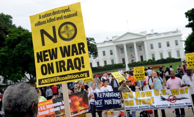 This photo taken Saturday, June 21, 2014, shows demonstrators protesting outside of the White House in Washington against renewed U.S. involvement in Iraq. In charting a new phase of American military engagement in Iraq on Thursday, President Barack Obama pledged that his war-weary country will not be 