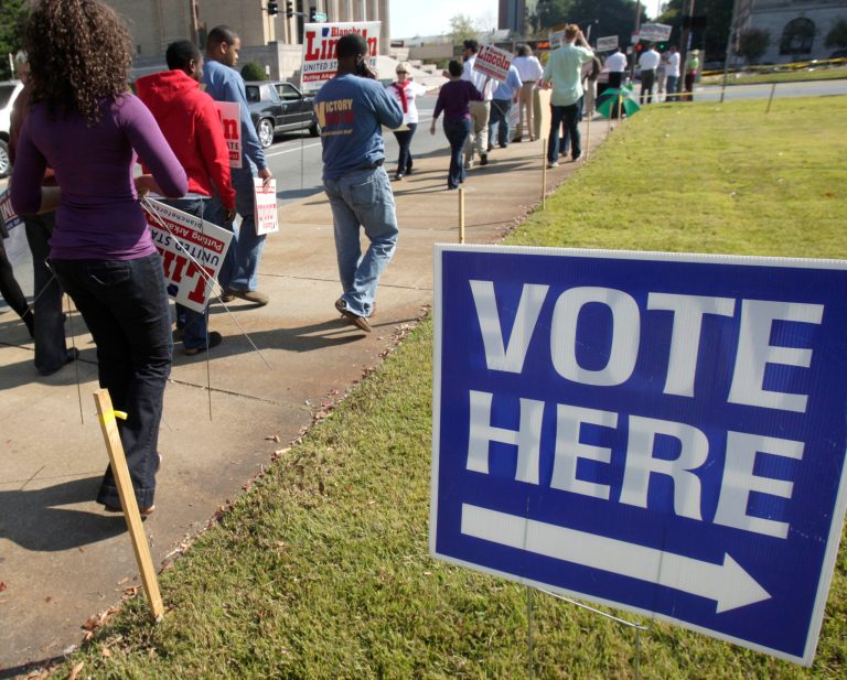 In this Oct. 18, 2010, photo, campaign workers and volunteers walks past an early voting polling place in Little Rock, Ark. (AP Photo/Danny Johnston)