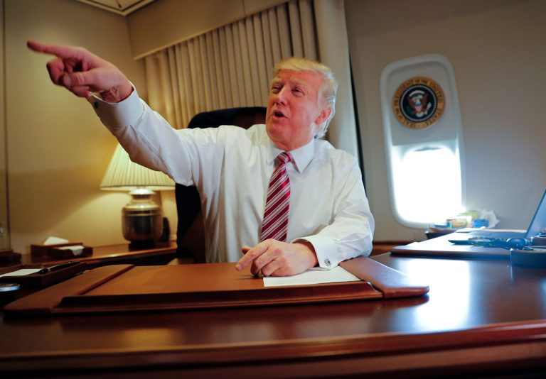 President Donald Trump points towards members of the media while seated at his desk on Air Force One upon his arrival at Andrews Air Force Base, Md., Thursday, Jan. 26, 2017. (AP Photo/Pablo Martinez Monsivais)