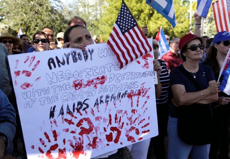 Sonia San Martin holds a sign during a protest in the Little Havana neighborhood of Miami on Saturday, Dec, 20, 2014 against President Barack Obama's plan to normalize relations with Cuba. (AP Photo/Lynne Sladky)