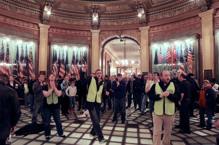   RETRANSMISSION FOR IMPROVED TONING--Union workers chant in the lower level of the Capitol rotunda in Lansing, Mich., Thursday, Dec. 6, 2012. Hundreds of chanting and cheering protesters streamed back into the Michigan Capitol after receiving a court order saying that the building must reopen. The pro-union crowd walked in as lawmakers were debating right-to-work legislation limiting union powers. The Republican-led House subsequently passed the bill with no Democratic support. (AP Photo/Carlos Osorio)  