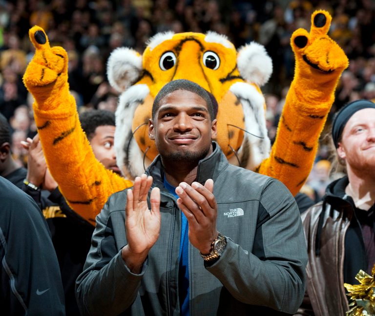 FILE - In this Feb. 15, 2014, file photo, Missouri's All-American defensive end Michael Sam claps during the Cotton Bowl trophy presentation at halftime of an NCAA college basketball game between Missouri and Tennessee in Columbia, Mo. The NFL draft will conclude with Rounds 4 through 7 on Saturday, and when and if Sam is selected is sure to be the most significant development. The Southeastern Conference defensive player of the year last season for Missouri came out as gay in media interviews this year.   (AP Photo/L.G. Patterson, File)