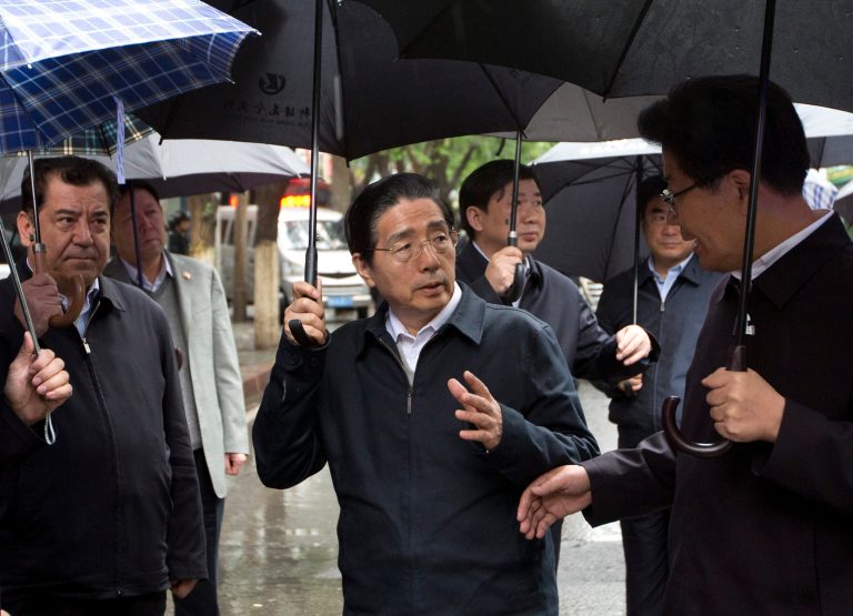 China's Public Security Minister Guo Shengkun, center, talks with Xinjiang Party Secretary Zhang Chunxian, right, as they visit the site of an explosion in Urumqi, northwest China's Xinjiang region, Thursday, May 22, 2014. Assailants in two SUVs plowed through shoppers while setting off explosives on a busy street market in China's volatile northwestern region of Xinjiang on Thursday, the local officials said, killing over two dozen people and injuring more than 90. The attack was the bloodiest in a series of violent incidents that Chinese authorities have blamed on radical separatists from the country's Muslim Uighur minority. (AP Photo/Andy Wong)