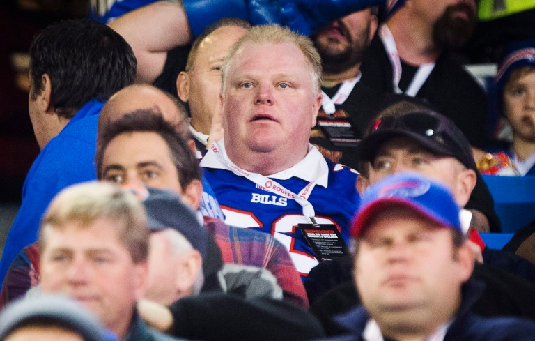 In this Sunday, Dec. 1, 2013 photo, Toronto Mayor Rob Ford watches the Buffalo Bills play the Atlanta Falcons during the first half of an NFL football game, in Toronto.  Saying he's a big Washington Redskins fan and will 