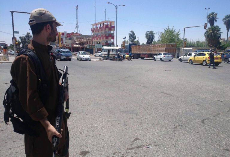 A fighter with the al-Qaida-inspired Islamic State of Iraq and the Levant (ISIL) takes control of a traffic intersection in the northern city of Mosul, 225 miles (360 kilometers) northwest of Baghdad, Iraq, Sunday, June 22, 2014. Sunni militants on Sunday captured two border crossings, one along the frontier with Jordan and the other with Syria, security and military officials said, as they pressed on with their offensive in one of Iraq's most restive regions. (AP Photo)
