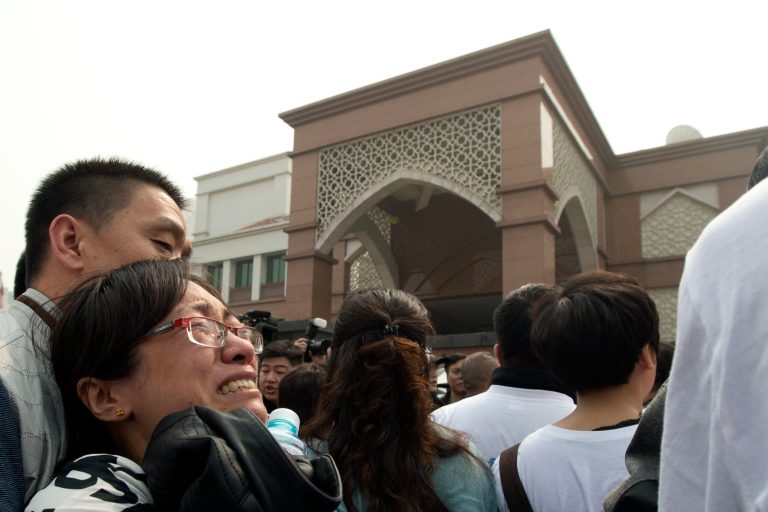 A relative of Chinese passengers onboard the Malaysia Airlines plane breaks down as she protests outside the Malaysian embassy in Beijing, China, Tuesday, March 25, 2014. Furious that Malaysia has declared their loved ones lost in a plane crash without physical evidence, Chinese relatives of the missing marched Tuesday to the Malaysia Embassy, where they threw plastic water bottles, tried to rush the gate and chanted, 