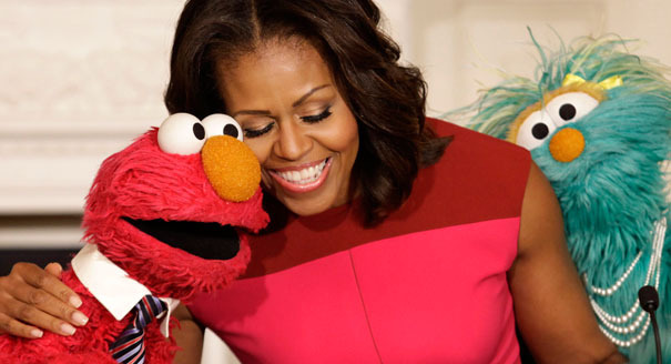 U.S. first lady Michelle Obama hugs PBS Sesame Street characters Elmo and Rosita after delivering remarks on marketing healthier foods to children at the White House in Washington October 30, 2013. Michelle Obama invited local schoolchildren to participate in the fall harvest of the White House Kitchen Garden. REUTERS/Yuri Gripas (UNITED STATES - Tags: POLITICS SOCIETY ENTERTAINMENT FOOD HEALTH TPX IMAGES OF THE DAY) - RTX14UAA