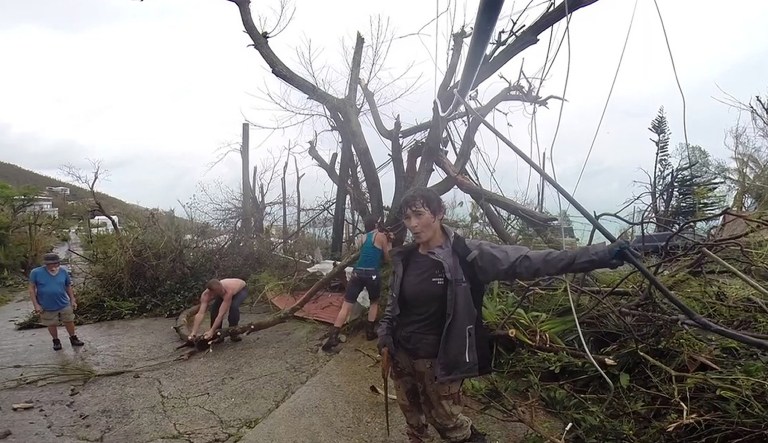 In this image made from video, neighbors clear debris from the road in St. Thomas, U.S. Virgin Islands on Thursday. Hurricane Irma weakened slightly Thursday with sustained winds of 175 mph, according to the National Hurricane Center. The storm had 185 mph winds for a more than 24-hour period, making it the strongest storm ever recorded in the Atlantic Ocean. The storm was expected to arrive in Cuba by Friday. It could hit the Florida mainland by late Saturday, according to hurricane center models. (AP Photo/Ian Brown)
