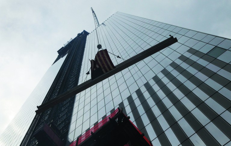 The ceremonial last beam is hoisted to the top of Four World Trade Center, Monday, June 25, 2012. The 72-floor, 977-foot tower is scheduled to open late next year. It's expected to be the first tower completed on the 16-acre site since the 9/11 attacks. (AP Photo/Mark Lennihan)