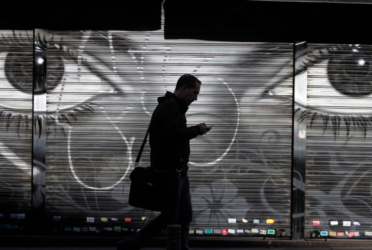 FILE - In this Thursday, Oct. 31, 2013, file photo, a man looks at his cellphone as he walks on the street in downtown Madrid. The National Security Agency tracks the locations of nearly 5 billion cellphones every day overseas, including those belonging to Americans abroad, The Washington Post reported Wednesday, Dec. 4, 2013. (AP Photo/Francisco Seco, File)