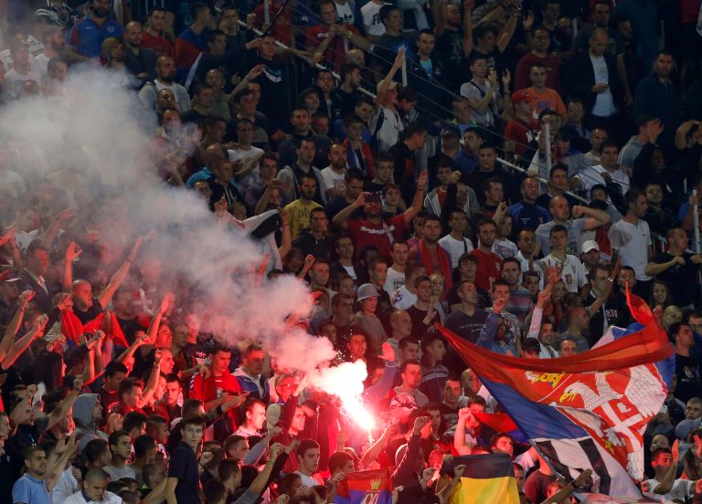 Serbian soccer fans react during the Euro 2016 Group I qualifying match between Serbia and Albania, at the Partizan stadium in Belgrade, Serbia, Tuesday, Oct. 14, 2014. The 2016 European Championship qualifier between Serbia and Albania was abandoned on Tuesday after skirmishes broke out on the pitch involving players and fans over an Albanian flag that was flown above the stadium by a drone. (AP Photo/Darko Vojinovic)
